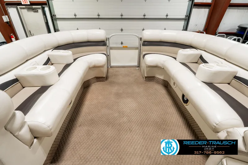 Slide: The Image of 2003 Bennington 2050 RL pontoon boat interior with plush seating in a showroom. - 22