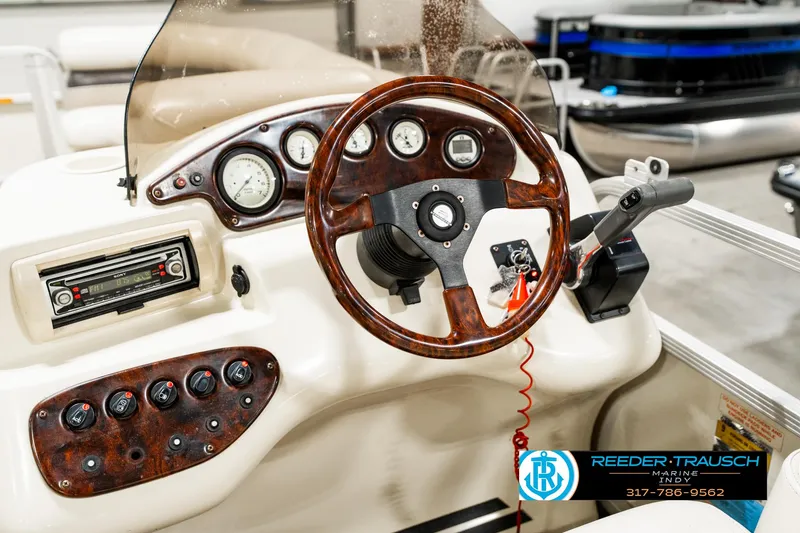 Slide: The Image of Steering console of a 2003 Bennington 2050 RL boat with wood accents and controls. - 31