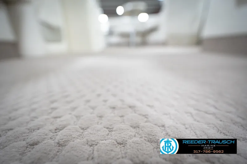 Slide: The Image of Carpeted interior of a 2003 Bennington 2050 RL boat, featuring Reeder-Trausch Marine logo. - 48