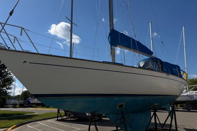 Slide: The Image of 1982 Morgan 383 sailboat on stands under a clear blue sky. - 19