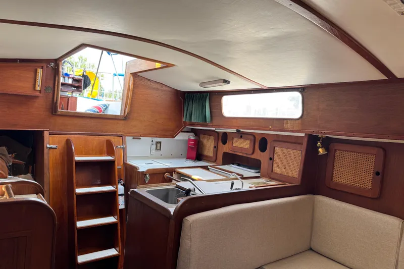 Slide: The Image of Interior of a 1982 Morgan 383 sailboat with wooden cabinetry and cozy seating. - 25
