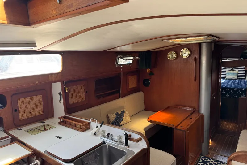 Slide: The Image of 1982 Morgan 383 yacht interior with wooden finish, cozy seating, and nautical decor. - 29
