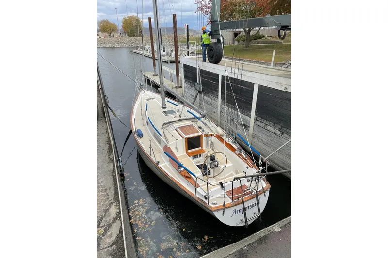 Slide: The Image of 1982 Morgan 383 sailboat docked in a canal, featuring a classic design and wooden accents. - 30