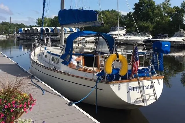 Slide: The Image of 1982 Morgan 383 sailboat docked at marina, featuring blue sail cover and American flag. - 32