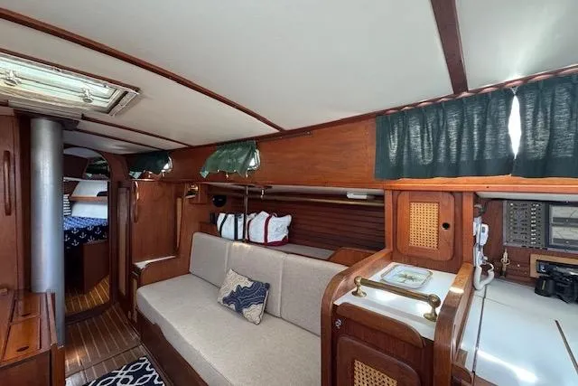 Slide: The Image of Interior of a 1982 Morgan 383 sailboat with wooden furnishings and cozy seating area. - 34