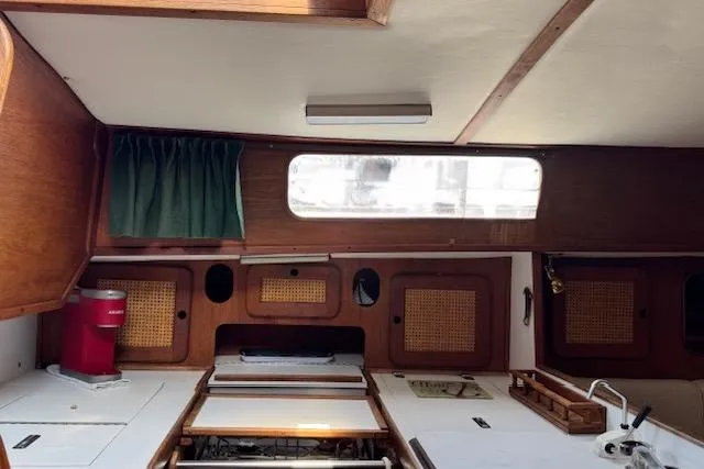 Slide: The Image of Interior of 1982 Morgan 383 sailboat with wooden cabinetry and compact kitchen area. - 8