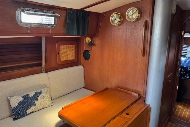 Slide: The Image of 1982 Morgan 383 yacht interior with wooden table, cushioned seating, and nautical decor. - 9