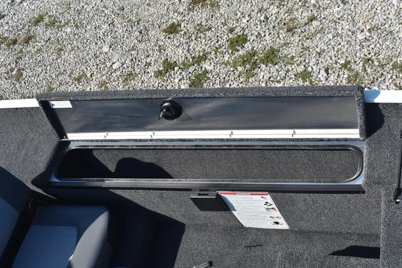 Slide: The Image of Open storage compartment in 2026 Lowe Skorpion 17 boat, with carpeted interior and latch. - 12