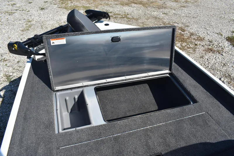 Slide: The Image of 2026 Lowe Skorpion 17 boat storage compartment open on gravel surface. - 15
