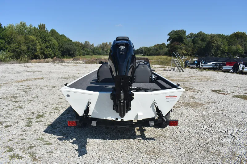 Slide: The Image of 2026 Lowe Skorpion 17 boat on gravel lot, rear view with outboard motor. - 6