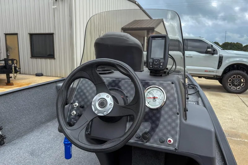 Slide: The Image of 2024 Bass Tracker Classic XL boat dashboard with steering wheel and Garmin GPS. - 11