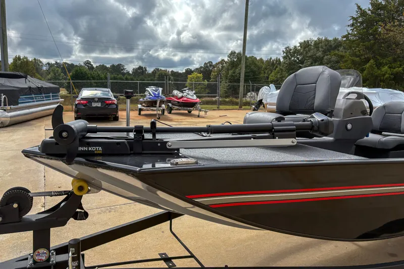 Slide: The Image of 2024 Bass Tracker Classic XL boat with Minn Kota motor, parked outdoors. - 3