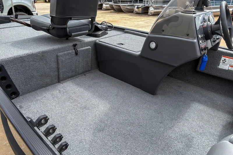 Slide: The Image of 2024 Bass Tracker Classic XL boat interior with gray carpet and steering console. - 6
