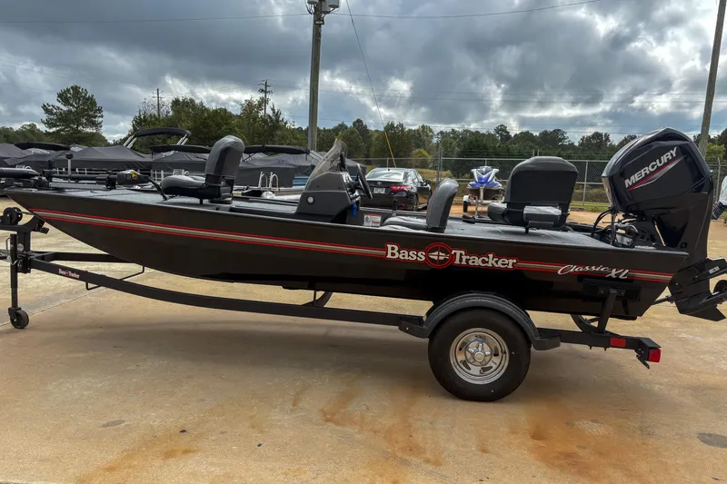 Slide: The Image of 2024 Bass Tracker Classic XL boat with Mercury engine on trailer, parked outdoors. - 8