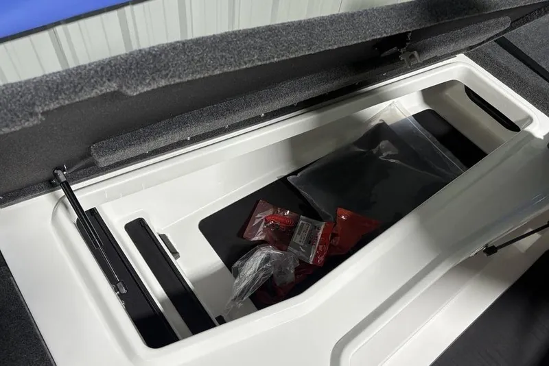 Slide: The Image of Storage compartment of 2026 Skeeter ZXR19 SE boat, open with accessories inside. - 13
