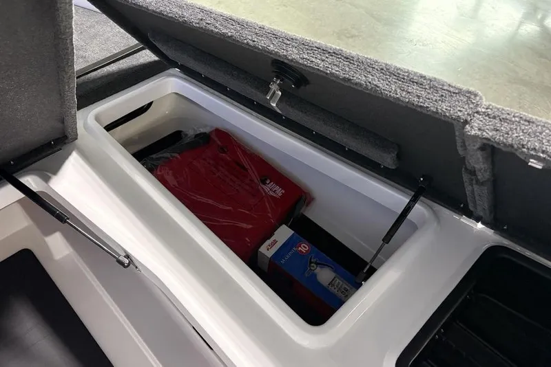 Slide: The Image of Open storage compartment in 2026 Skeeter ZXR19 SE boat, containing safety equipment and supplies. - 14