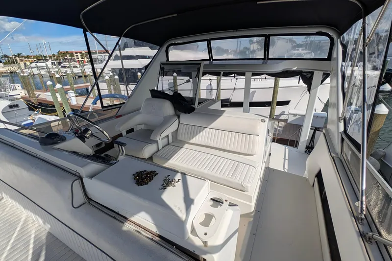 Slide: The Image of 1994 Carver 370 Aft Cabin Motor Yacht interior with helm and seating area at marina. - 13