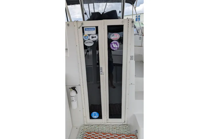 Slide: The Image of 1994 Carver 370 Aft Cabin Motor Yacht entrance with stickers and fire extinguisher. - 19