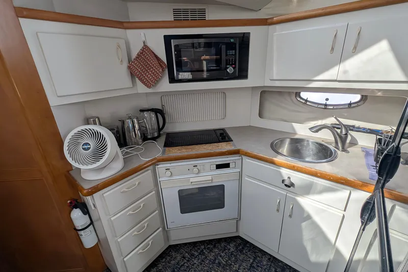 Slide: The Image of 1994 Carver 370 Aft Cabin Motor Yacht kitchen with stove, microwave, and sink. - 31