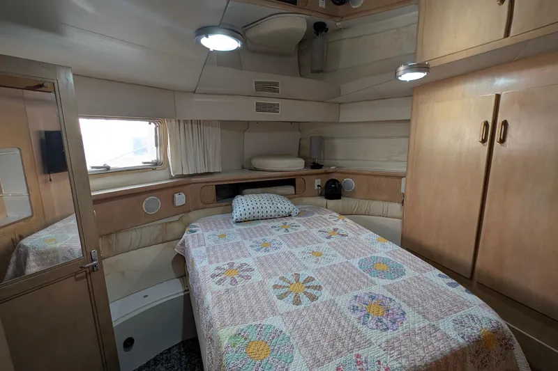 Slide: The Image of 1994 Carver 370 Aft Cabin Motor Yacht bedroom with quilted bedspread and wooden cabinetry. - 42