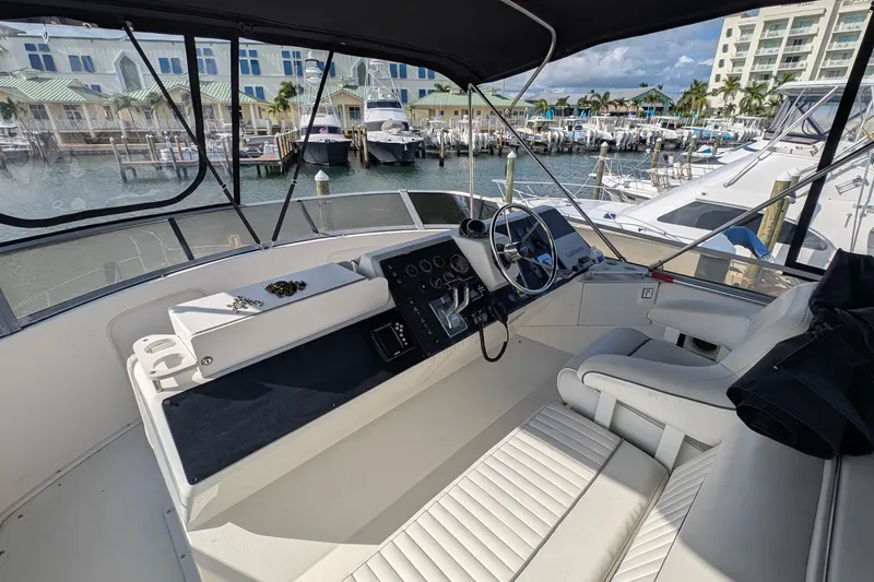 Slide: The Image of 1994 Carver 370 Aft Cabin Motor Yacht helm with marina view, featuring modern controls. - 14