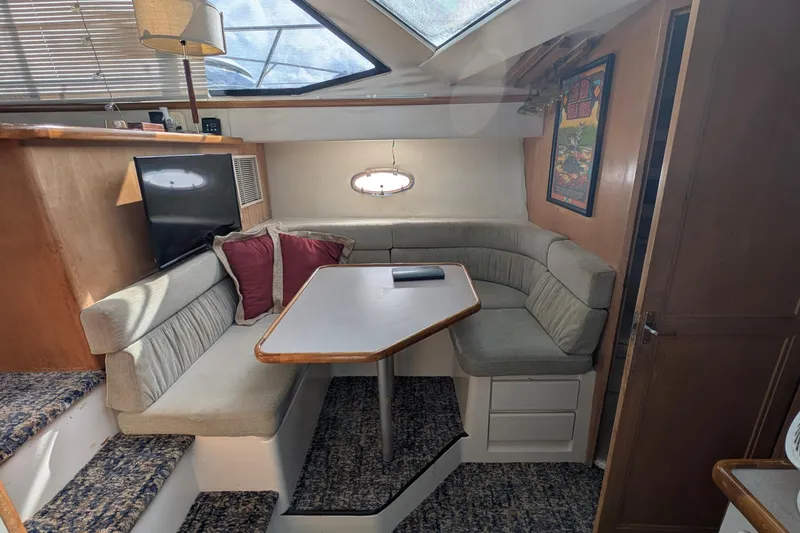 Slide: The Image of 1994 Carver 370 Aft Cabin Motor Yacht interior with cozy dining area and TV. - 30
