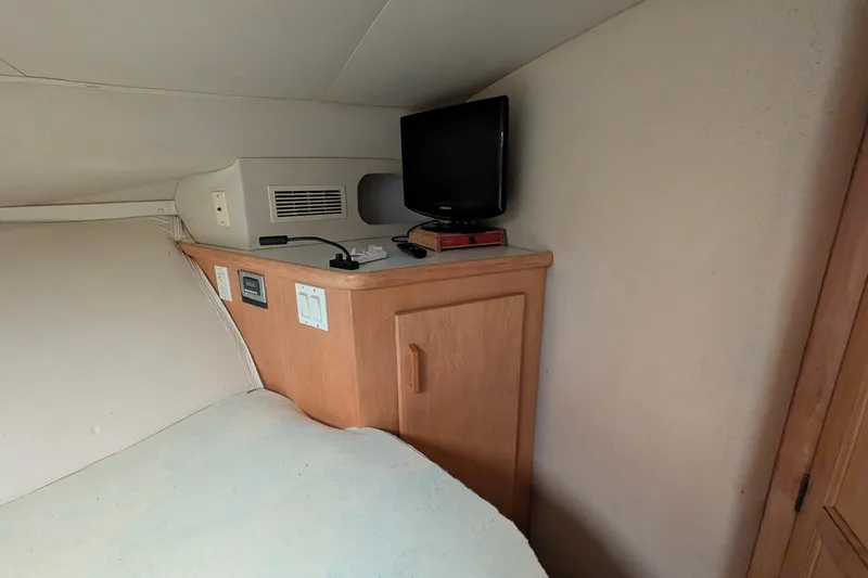 Slide: The Image of 1994 Carver 370 Aft Cabin Motor Yacht interior with TV and wooden cabinetry. - 37