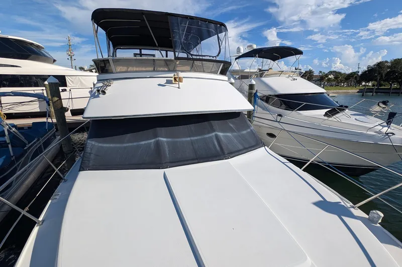 Slide: The Image of 1994 Carver 370 Aft Cabin Motor Yacht docked at marina under blue sky. - 5