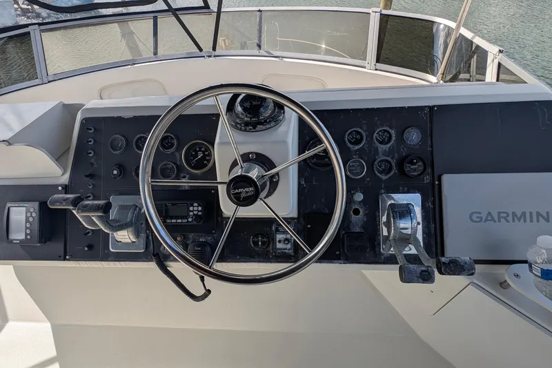 Slide: The Image of 1994 Carver 370 Aft Cabin Motor Yacht helm with steering wheel and Garmin navigation system. - 8