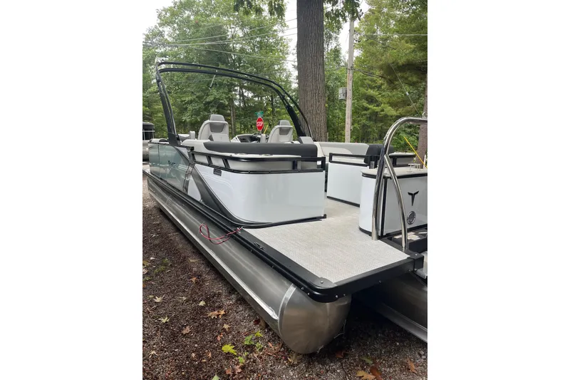 Slide: The Image of 2026 Tahoe 23 LTZ Quad Lounger pontoon boat in a wooded area. - 11