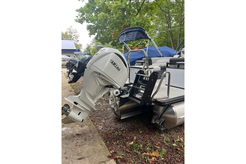 Slide: The Image of 2026 Tahoe 23 LTZ Quad Lounger with Yamaha outboard motor, parked outdoors. - 13