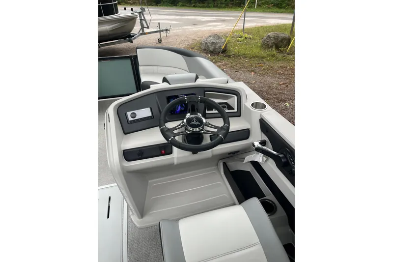Slide: The Image of 2026 Tahoe 23 LTZ Quad Lounger boat interior with steering wheel and control panel. - 9