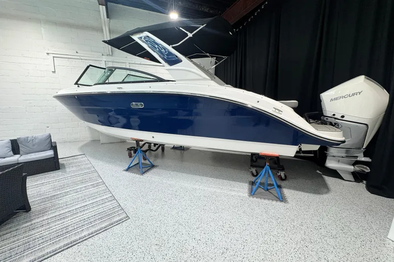 The Image of 2025 Sea Ray SDX 250 Outboard boat at sunset, parked on pavement. - 0