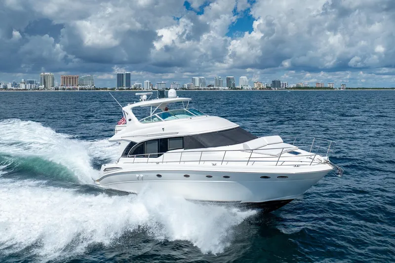 The Image of 2001 Sea Ray 540 Cockpit Motor Yacht cruising on open water with city skyline backdrop. - 0