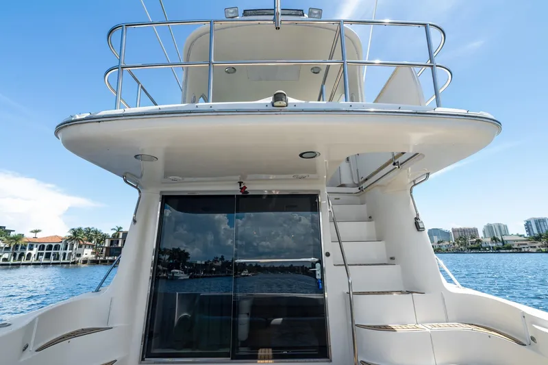 Slide: The Image of 2001 Sea Ray 540 Cockpit Motor Yacht on water, showcasing rear deck and upper balcony. - 11