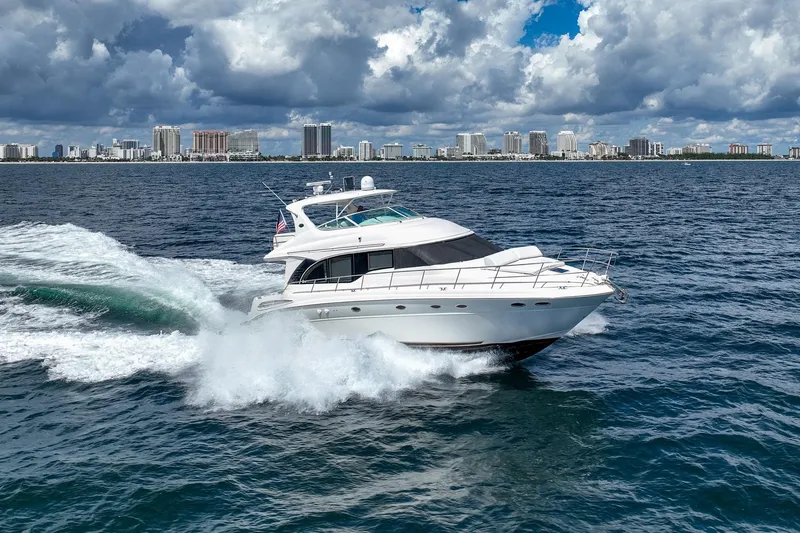 Slide: The Image of 2001 Sea Ray 540 Cockpit Motor Yacht cruising on ocean with city skyline backdrop. - 42