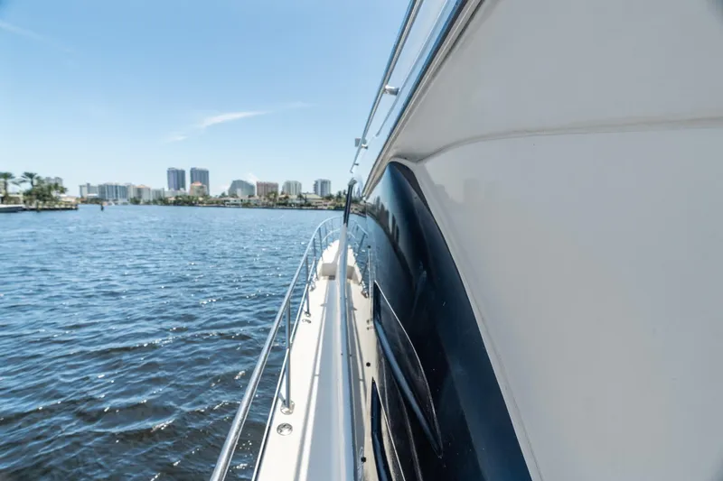 Slide: The Image of Side view of 2001 Sea Ray 540 Cockpit Motor Yacht on water, city skyline in background. - 44