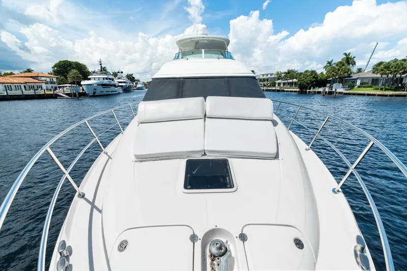 Slide: The Image of 2001 Sea Ray 540 Cockpit Motor Yacht cruising on a sunny day, surrounded by waterfront homes. - 7