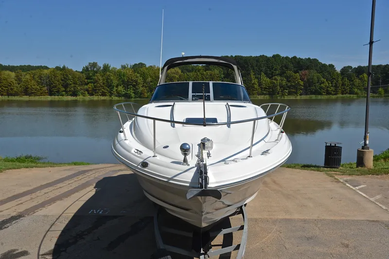 Slide: The Image of 2003 Sea Ray 320 Sundancer boat on trailer by a scenic lake. - 22