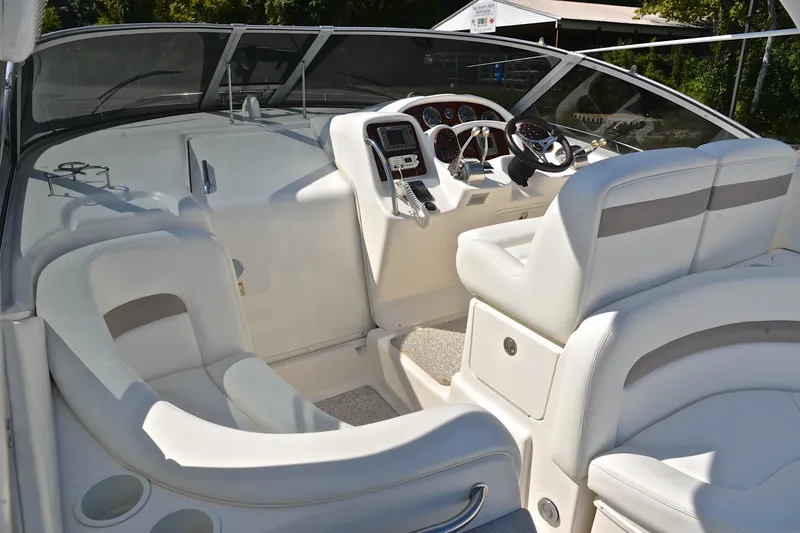 Slide: The Image of 2003 Sea Ray 320 Sundancer cockpit with white seating and modern dashboard controls. - 25