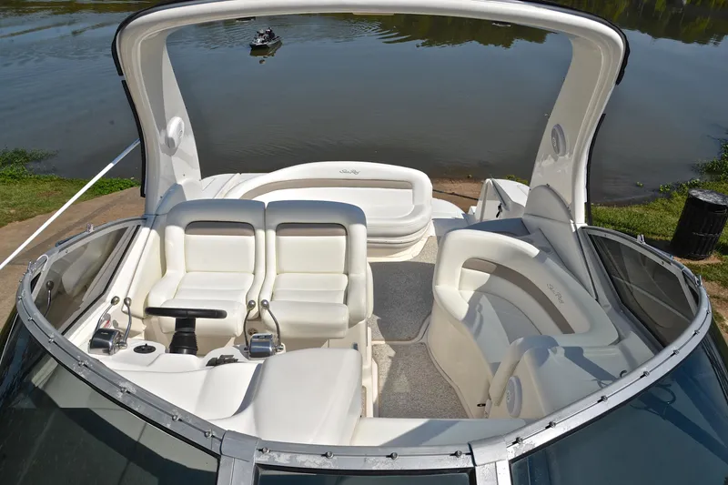 Slide: The Image of 2003 Sea Ray 320 Sundancer boat interior with white seating, docked by a calm river. - 29