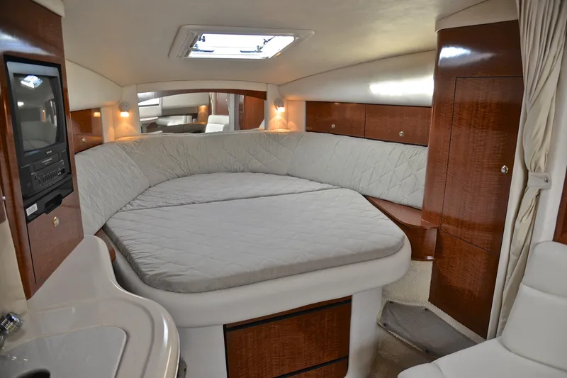 Slide: The Image of 2003 Sea Ray 320 Sundancer cabin interior with cozy bed and wooden cabinetry. - 36