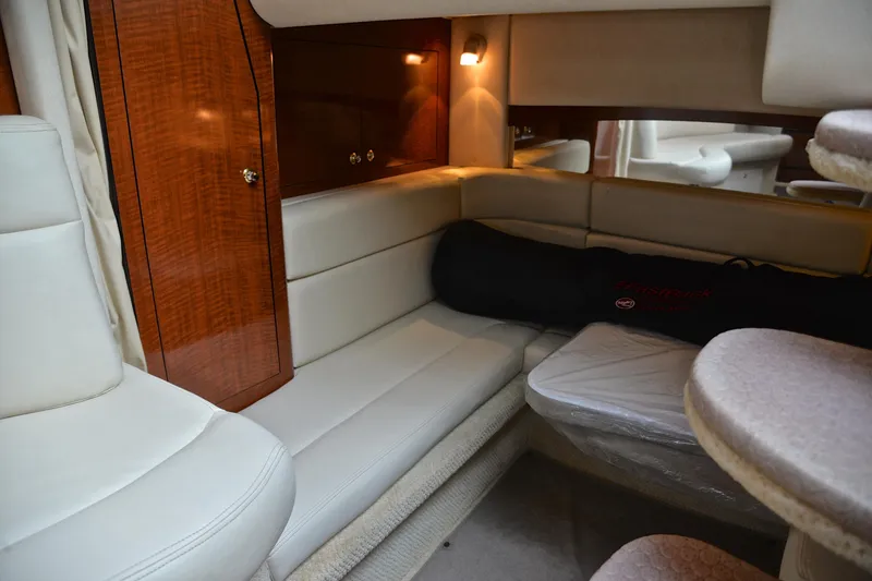 Slide: The Image of Interior of 2003 Sea Ray 320 Sundancer yacht with plush seating and wooden cabinetry. - 40