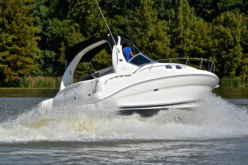 Slide: The Image of 2003 Sea Ray 320 Sundancer cruising on a scenic lake with lush greenery. - 5