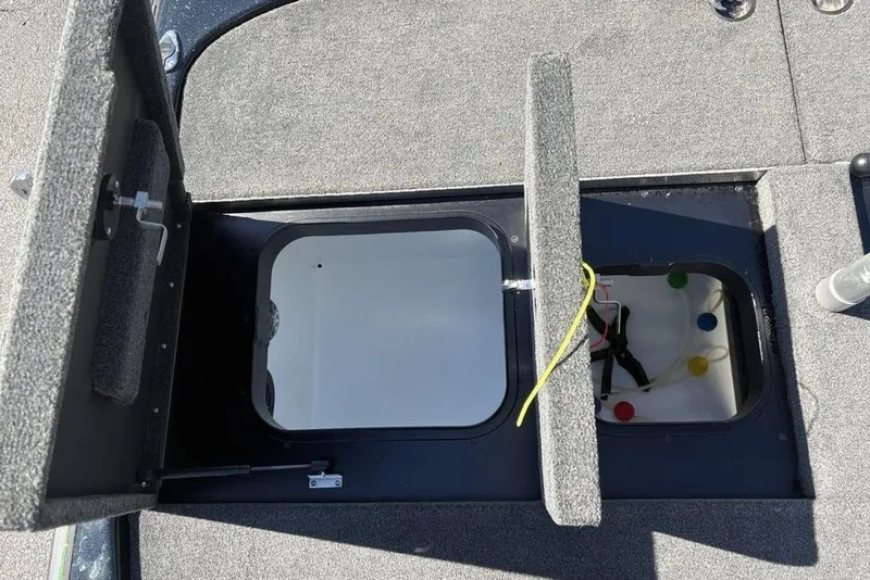 Slide: The Image of 2024 Skeeter ZXR20 boat storage compartment with open hatch and visible wiring. - 26