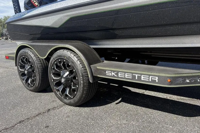 Slide: The Image of 2024 Skeeter ZXR20 boat trailer with stylish black wheels and sleek design. - 31