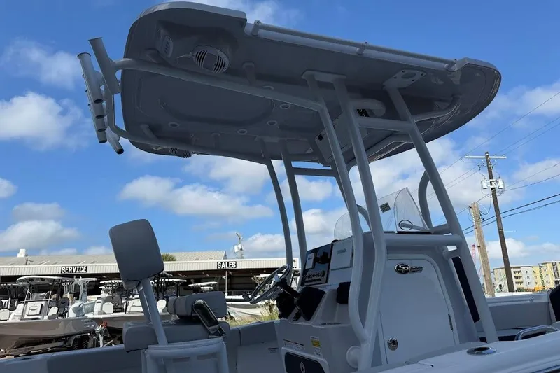 Slide: The Image of 2025 Sea Pro 225FLX Sandbar boat with T-top and console, under blue sky. - 5