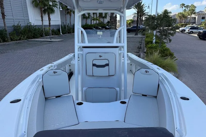 Slide: The Image of 2025 Sea Pro 225FLX Sandbar boat interior with seating and console, parked outdoors. - 7
