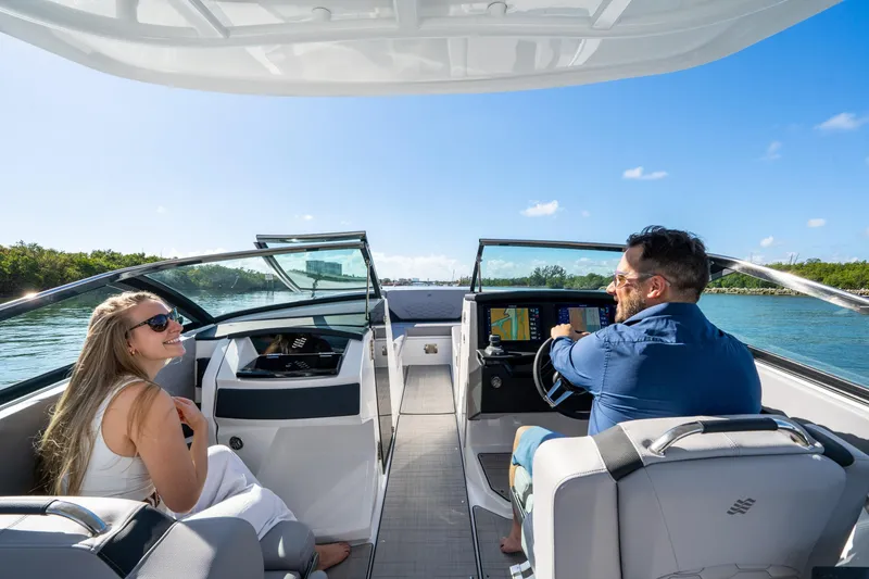 Slide: The Image of 2026 Four Winns H9 OB boat with two people enjoying a sunny day on the water. - 10