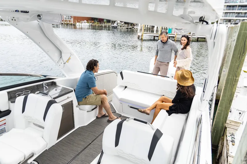 Slide: The Image of 2026 Four Winns H9 OB boat with people enjoying the spacious deck by the water. - 12